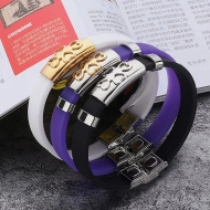 Macro view of purple and white silicone couple bracelets with gold and silver metal charms