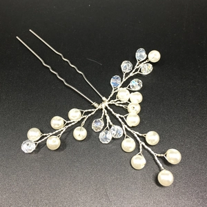 Close-up of silver wire hair pin with white pearls and clear crystal leaves for brides