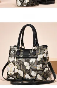 Vista dettagliata della borsa a fiori con zip dorata e tracolla regolabile