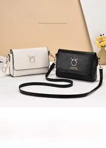 Detail of trendy crossbody bags featuring gold reindeer ring hardware and leather texture