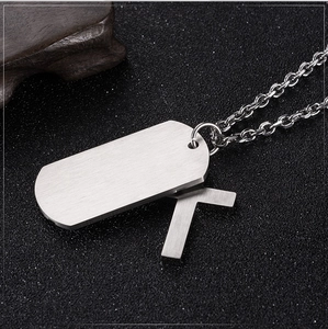 Macro shot of silver stainless steel double pendant featuring cross and military dog tag