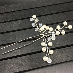 Detailed close-up of handmade bridal hair pin with silver wire, pearls and crystals