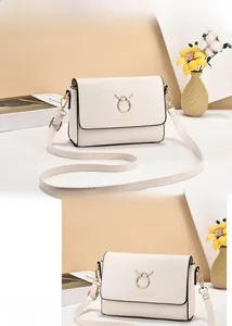 Close-up of beige crossbody bag with golden deer horn hardware and leather texture