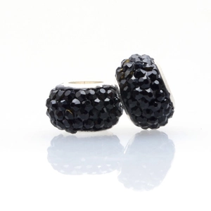 Close-up of two black crystal-encrusted beads with silver inner rings for DIY bracelets