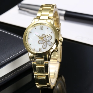 Detail of golden cloisonne watch with floral mother-of-pearl dial on a black surface