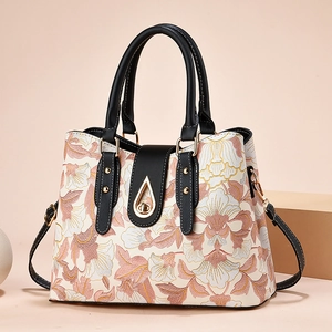 Elegante borsa jacquard beige a fiori con manici in pelle nera e chiusura dorata