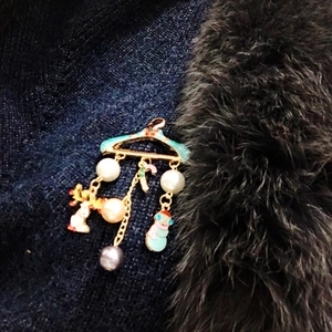 Christmas brooch with Santa, reindeer and candy cane charms on a black sweater