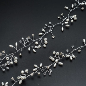 Close-up of handmade bridal hair vine with white pearls and crystals on silver wire