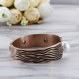 Bracelet perle en or rose avec texture vague noire et éléments de magnétothérapie