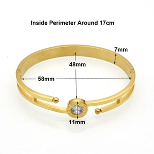 Detailed view of gold Roman numeral hollow bangle with center zircon and snap closure