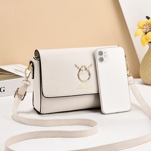 Minimalist beige crossbody bag with golden deer logo and adjustable shoulder strap