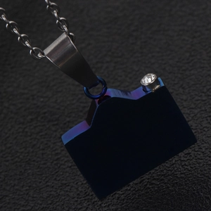 Macro detail of navy blue camera pendant with sparkling rhinestone on steel chain