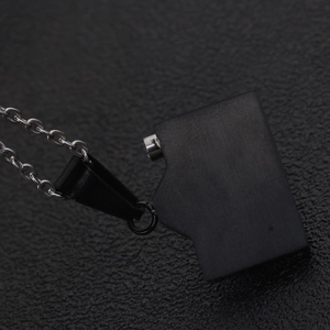 Macro shot of vintage black matte camera pendant with O-chain on textured leather