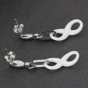 Infinity figure-eight ceramic earrings with stainless steel studs on black background
