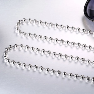 Polished titanium steel ball chain necklace for men and women on brushed metal surface