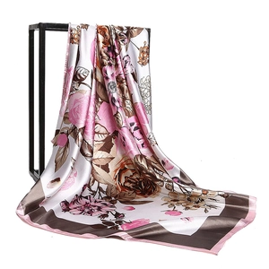 Floral silk satin square scarf with elegant botanical patterns on a professional metal stand