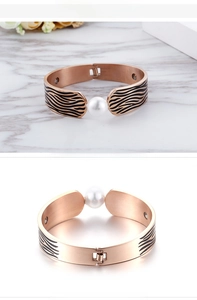 Détail d'un bracelet jonc or rose avec rayures zébrées et incrustation de perle ronde