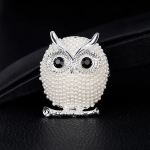 Exquisite silver owl brooch with white pearls and black crystal eyes on dark leather