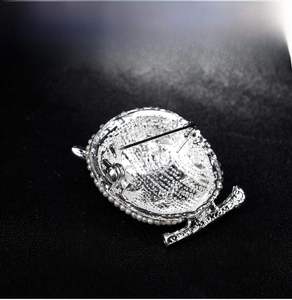 Macro view showing the sturdy silver pin clasp and pearl inlay on owl brooch back