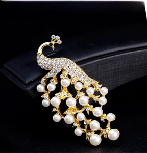 Macro detail of the 18k gold peacock brooch with intricate white pearls and crystals