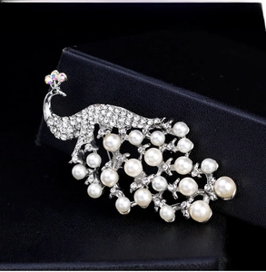 Close-up of elegant peacock brooch with white pearls and sparkling crystal inlay
