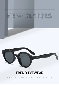 Detailed macro view of trendy oval sunglasses featuring metallic rivets and dark lenses
