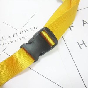 Macro view of yellow nylon strap with a black plastic buckle on a laser waist bag