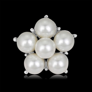 Macro shot of silver brooch with six white pearls in a floral cluster on black background
