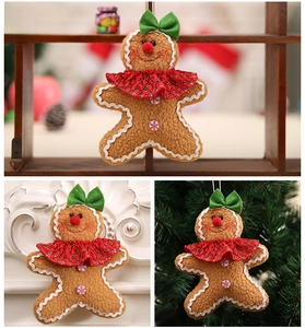 Detail of female gingerbread man plush hanging ornament with green bow and red collar