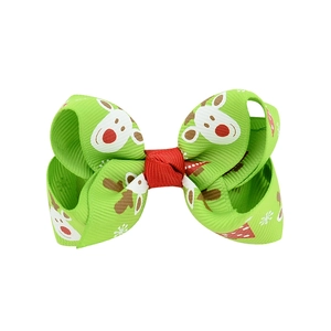 Christmas hair clip with green bow featuring red reindeer and white snowflakes patterns