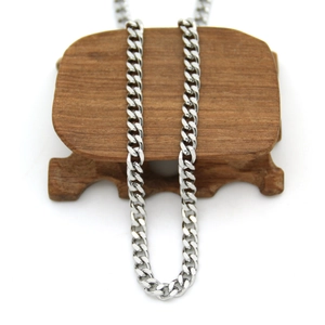 Detailed view of a 3mm silver Cuban chain necklace on a dark wooden display stand