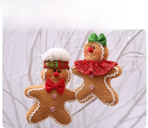 Close-up of plush gingerbread man ornaments with festive scarves on a winter branch