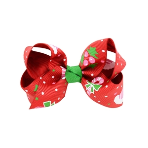 Detail of Christmas bow hair clip with red polka dots and candy cane stripe patterns