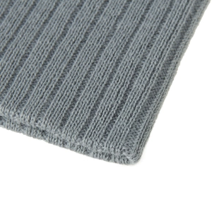 Gros plan sur la maille côtelée grise et les fibres de laine douce de ce bonnet d'hiver