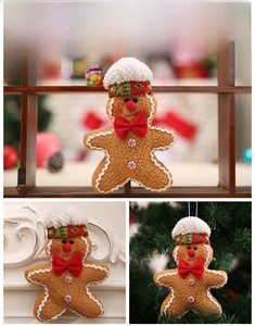 Detail of gingerbread man Christmas ornament with chef hat and bow on holiday tree