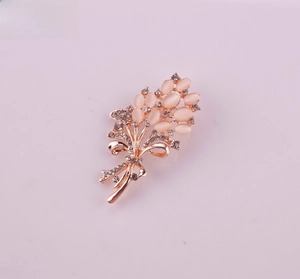 Close-up of a rose gold flower bouquet brooch with opal petals and crystal bow detail