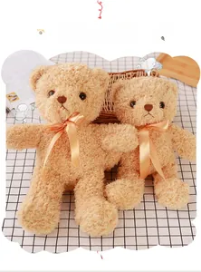 Detail of two teddy bears in 30cm and 35cm sizes with orange bows on a checkered cloth