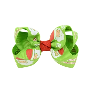 Christmas hair bow for kids featuring Santa Claus prints and Merry Christmas text