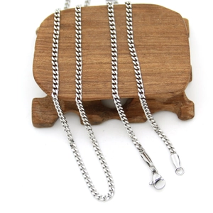 Macro view of 3mm silver stainless steel Cuban chain with lobster clasp on wood