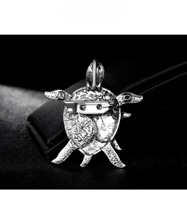 Macro shot of silver turtle brooch back showing pin clasp and dual pendant loop feature