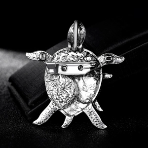 Silver turtle brooch in shell material showing a detailed macro view of the back pin closure