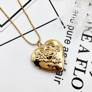 Detailed close-up of a gold heart-shaped locket featuring an embossed rose design