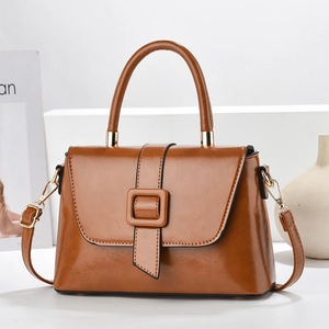 Détail du sac en similicuir caramel avec ferrures dorées et boucle carrée élégante