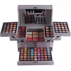 Paleta de maquillaje profesional multinivel con sombras y pinceles en estuche plateado