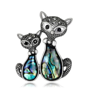 Detail of silver cat brooch with glittering grey crystals and blue-green abalone shell