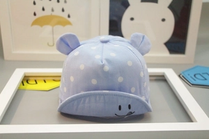 Detail of baby sun hat with white polka dots, 3D ears, and embroidered smiley face