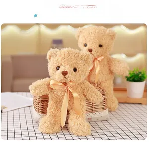 Detail of two light brown teddy bears with curly plush fur and champagne silk ribbons