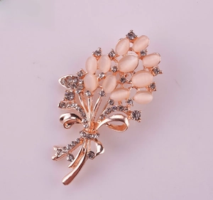 Detailed close-up of wheat ear brooch with opal stones and rhinestones on rose gold base
