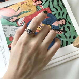 Detailed view of a vintage S925 sterling silver daisy ring worn on a finger