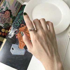 Artistic lifestyle shot of a minimalist S925 silver double bead open ring on a hand